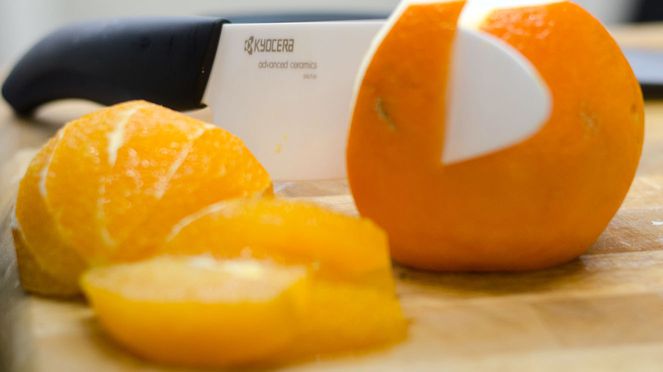 
                    Kyocera Keramik Kochmesser beim Schneiden einer Orange
